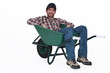 A man resting in a wheelbarrow.