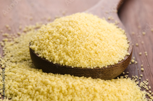 Photo: couscous in wooden spoon on kitchen table couscous in wooden spoon on kitchen table