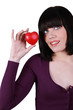 Photo: Young woman holding a small red heart Young woman holding a small red heart