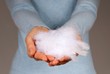 hand holding white feathers