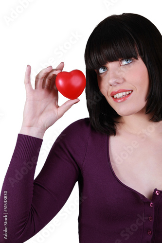 Photo: Young woman holding a small red heart Young woman holding a small red heart