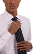 Businessman straightening his tie