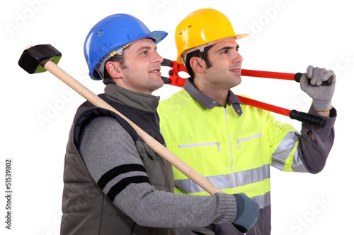 Photo: Two manual workers stood together looking into the distance Two manual workers stood together looking into the distance