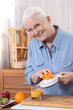 Photo: Elderly woman pouring freshly squeezed orange juice Elderly woman pouring freshly squeezed orange juice