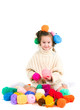 girl with knitting spokes and balls of threads in hair