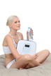 Young woman in her underwear with scales and a bottle of water