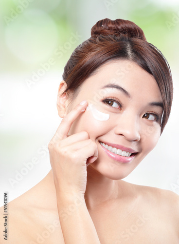 Photo: Beauty young woman applying cosmetic cream Beauty young woman applying cosmetic cream