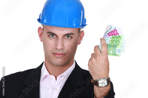 Photo: A male architect with his hand full of cash. A male architect with his hand full of cash.
