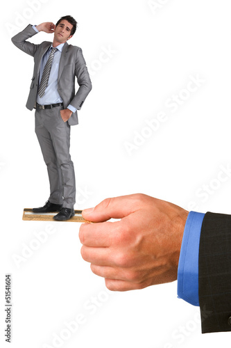Photo: Businessman standing on a credit card Businessman standing on a credit card