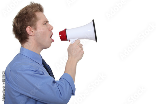 Photo: young businessman shouting in loudspeaker young businessman shouting in loudspeaker