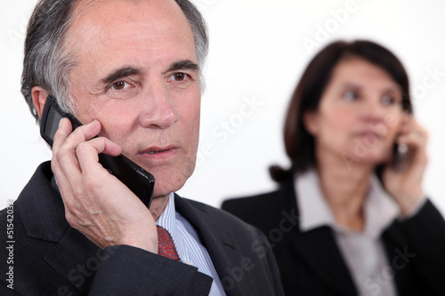 Photo: Executives on the phone Executives on the phone