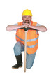 Construction worker leaning on a pickaxe