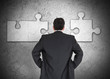 Businessman figuring out puzzle