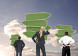 Photo: Group of businesspeople looking at empty signposts Group of businesspeople looking at empty signposts