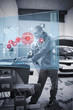 Mechanic typing while consulting futuristic interface
