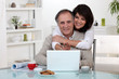 Photo: Couple smiling in front of their laptop Couple smiling in front of their laptop