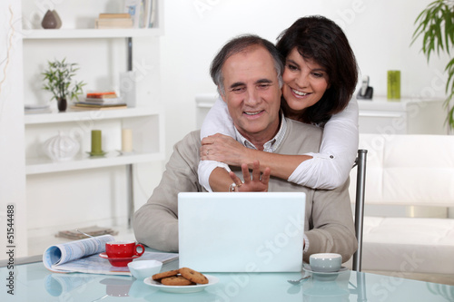 Photo: Couple smiling in front of their laptop Couple smiling in front of their laptop