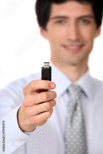Photo: Businessman holding a usb key Businessman holding a usb key