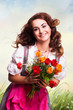 junge Frau im Dirndl mit einem Strauß Tulpen