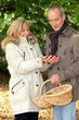 Photo: Couple collecting chestnuts in the woods Couple collecting chestnuts in the woods