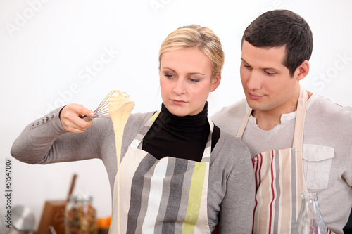 Photo: Young man and young woman making a cake dough Young man and young woman making a cake dough