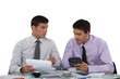 Two businessmen checking calculations