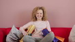 Young smiling girl with shopping bags sitting on the sofa