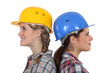 Two female builders standing back to back