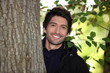 Man behind the tree trunk