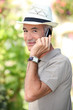 Photo: Man with hat and phone Man with hat and phone