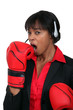 A black businesswoman yawning with boxing gloves on.