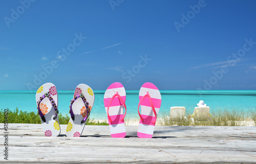 Photo: Two pairs of flip-flops against ocean. Exuma, Bahamas Two pairs of flip-flops against ocean. Exuma, Bahamas
