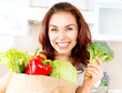 Happy Young Woman with vegetables in shopping bag. Diet Concept