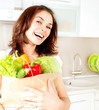 Happy Young Woman with vegetables in shopping bag. Diet Concept