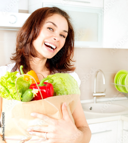 Photo: Happy Young Woman with vegetables in shopping bag. Diet Concept Happy Young Woman with vegetables in shopping bag. Diet Concept