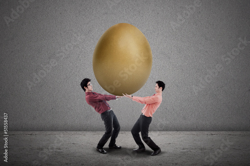 Photo: Business partnership carry golden egg Business partnership carry golden egg