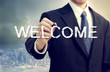 Business man writing WELCOME