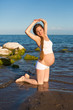 Pregnant woman in sports bra doing exercise  on yoga pose