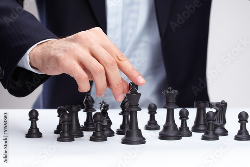 Photo: Business man moving chess figure Business man moving chess figure