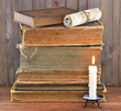 Old stacked books with candle