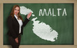 Teacher showing map of malta on blackboard