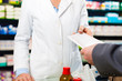 Female pharmacist with customer in pharmacy