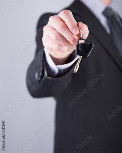 Photo: Car salesman or rental man giving a car key to someone Car salesman or rental man giving a car key to someone