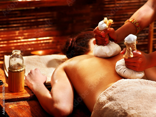 Photo: Woman having massage with pouch. Woman having massage with pouch.