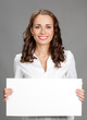 Businesswoman showing signboard, over grey