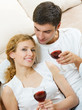 Cheerful couple with glasses of redwine