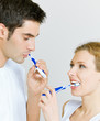 Cheerful young couple cleaning teeth together