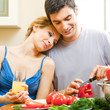 Cheerful young cooking couple at home