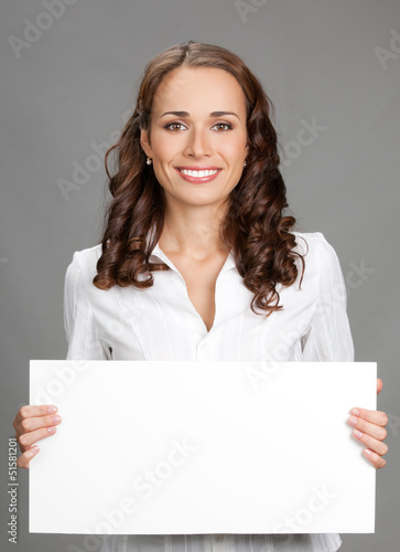 Photo: Businesswoman showing signboard, over grey Businesswoman showing signboard, over grey