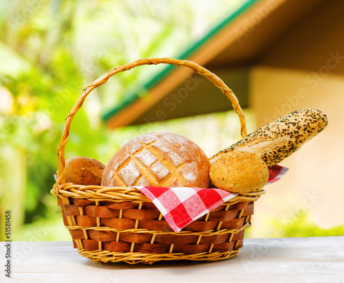 Photo: Fresh bread in the basket on natural background Fresh bread in the basket on natural background
